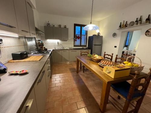 a kitchen with a table with a bowl of fruit on it at Affittacamere Ca' de Mazapedar in San Lorenzo