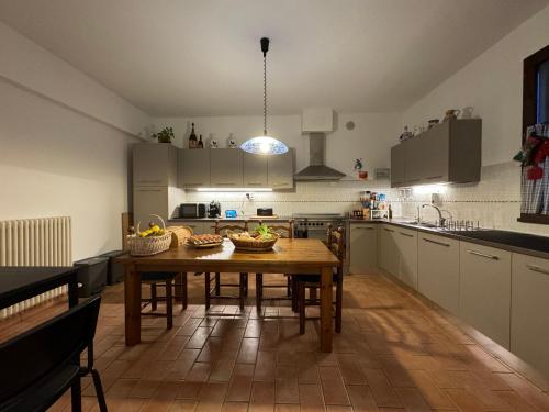 a kitchen with a wooden table with baskets of fruit on it at Affittacamere Ca' de Mazapedar in San Lorenzo
