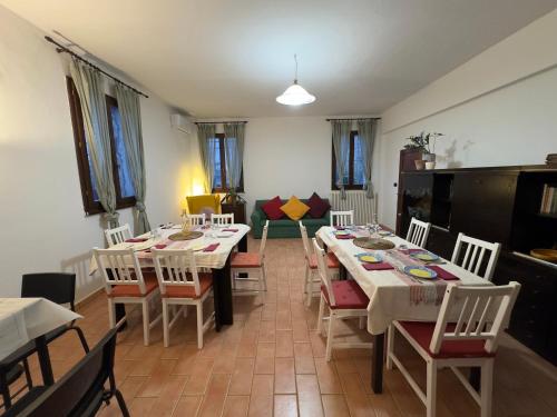 a dining room with tables and chairs and a couch at Affittacamere Ca' de Mazapedar in San Lorenzo