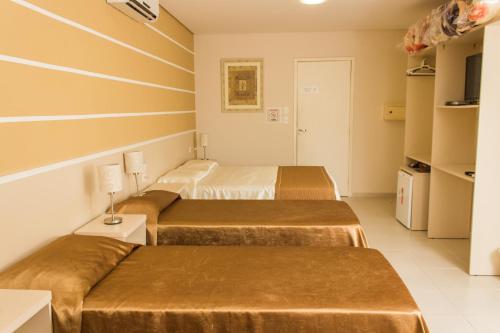 a hotel room with two beds and a tv at Pousada Cataratas in Foz do Iguaçu