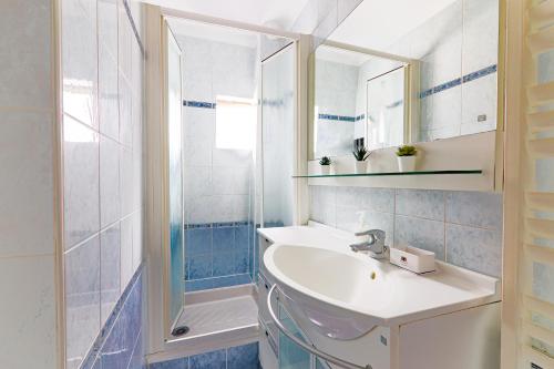 une salle de bain blanche avec un lavabo et une douche dans l'établissement Appartement Quartier Le Marais Free Netflix, à Paris