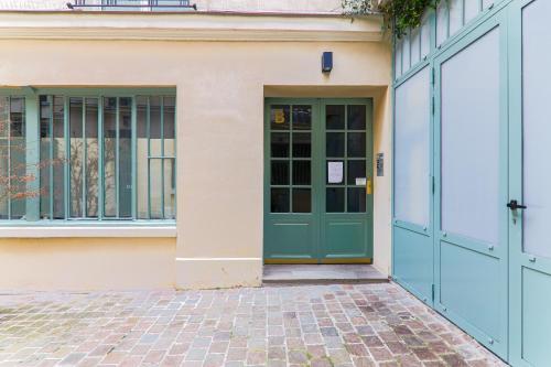 - un bâtiment avec une porte verte et 2 fenêtres dans l'établissement Appartement Quartier Le Marais Free Netflix, à Paris