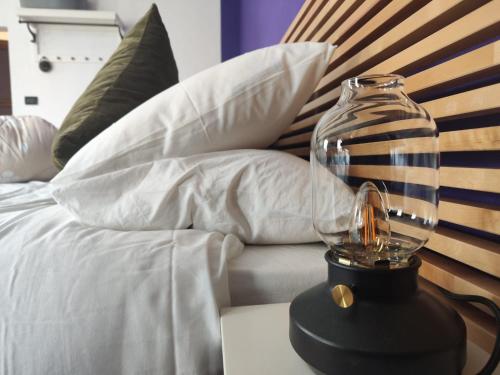 a glass jar on a table next to a bed at Affittacamere Ca' de Mazapedar in San Lorenzo