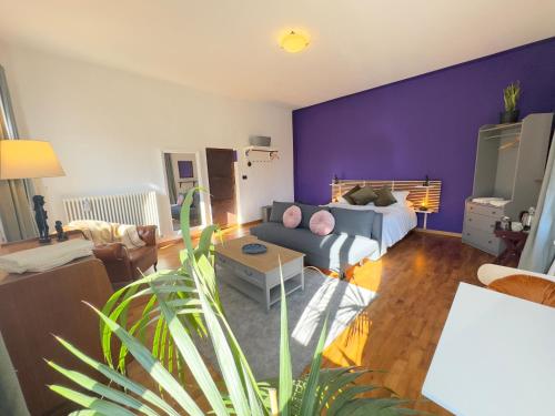 a living room with a couch and a purple wall at Affittacamere Ca' de Mazapedar in San Lorenzo