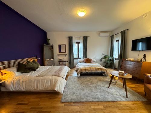 a bedroom with two beds and a purple wall at Affittacamere Ca' de Mazapedar in San Lorenzo
