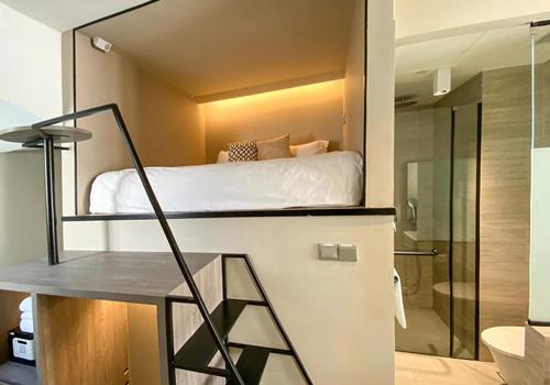 ein Schlafzimmer mit einem Bett und einer Dusche in einem Zimmer in der Unterkunft ST Signature Jalan Besar, SHORT OVERNIGHT, 8 Hours, 1159PM-8AM in Singapur