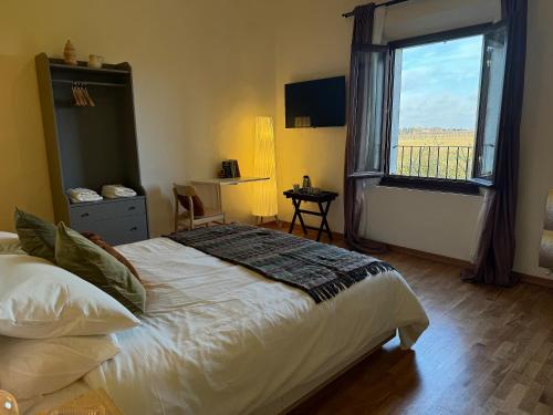 a bedroom with a bed and a large window at Affittacamere Ca' de Mazapedar in San Lorenzo