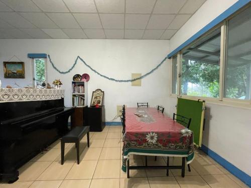 a dining room with a table and a piano at Joyfarm Hostel in Tung-hsing