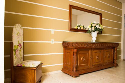a room with a mirror and a dresser and a chair at Pousada Cataratas in Foz do Iguaçu