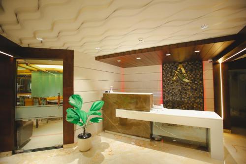 a bathroom with a sink and a potted plant at Akhil Classic in Trivandrum