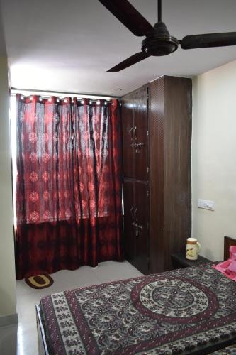 een slaapkamer met een bed en een plafondventilator bij BHARDWAJ CHAMBER in Jaipur