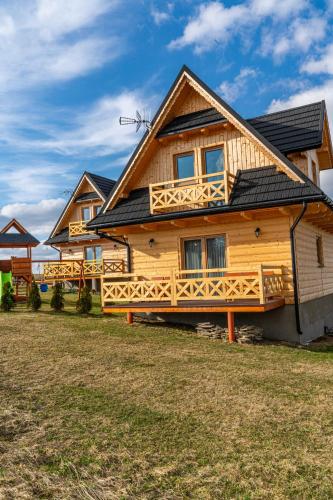 a log house with a gambrel roof at Domki Tatrzański Przystanek in Białka Tatrzanska