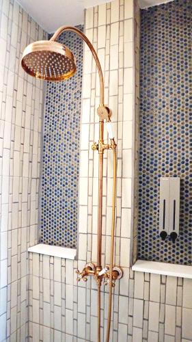 a shower in a bathroom with blue and white tiles at Buri Sriping Riverside Resort & Spa in Chiang Mai