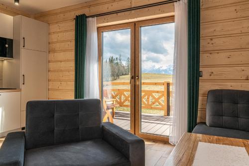 a living room with a table and chairs and a sliding glass door at Domki Tatrzański Przystanek in Białka Tatrzanska