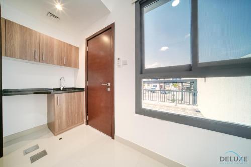 a kitchen with a wooden door and a window at Unbeatable Price, Perfect for Groups with Sea Views by Deluxe Holiday Homes in Fujairah