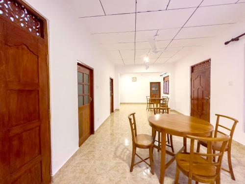 a dining room with a wooden table and chairs at Bungalow By Tropical Villa in Weligama