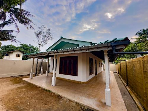 a small house with a green roof at Bungalow By Tropical Villa in Weligama