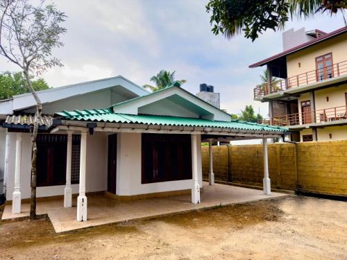 a house with a fence in front of it at Bungalow By Tropical Villa in Weligama