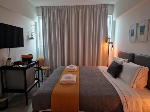 MARTIN Nicosia City Suites في نيقوسيا: غرفة فندق عليها سرير وفوط
