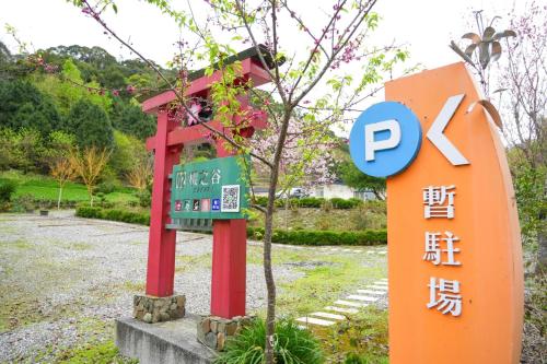 a sign next to a red chair next to a sign at 赤科山櫻之谷咖啡民宿 in Chiu-t'ien