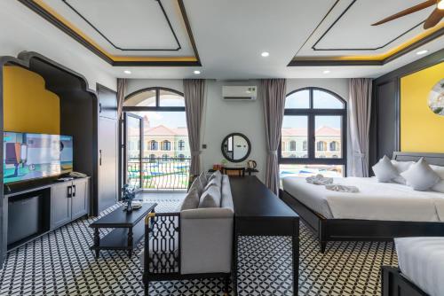 a hotel room with two beds and a television at Le Palmier Phu Quoc Hotel - Free Shuttle To Grand World in Phu Quoc