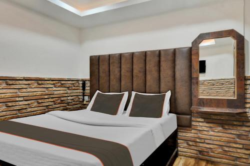 a bedroom with a large bed with a wooden headboard at Collection O New Hotel River Side in Bilāspur