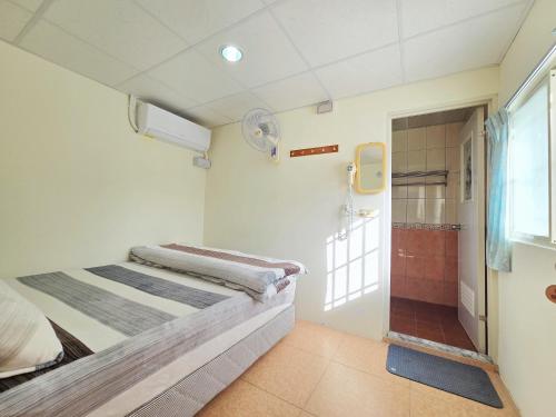 a small room with a bed and a shower at 赤科山櫻之谷咖啡民宿 in Chiu-t'ien