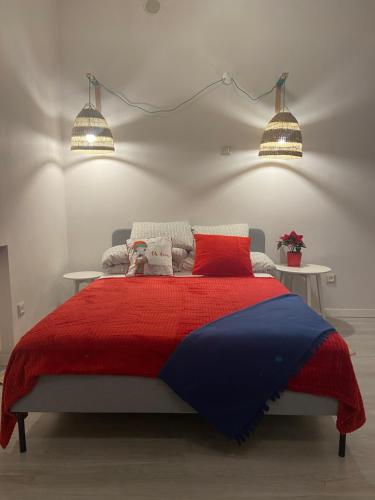 1 dormitorio con 1 cama roja y azul con 2 luces en Nest Apartment en Sopot