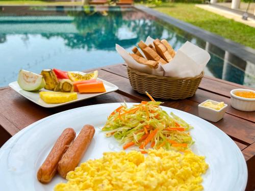 a plate of scrambled eggs and other food on a table at Bungalow By Tropical Villa in Weligama