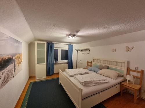 Ferienhaus Villa Mullewapp في نوردين: غرفة نوم بسرير كبير مع ستائر زرقاء