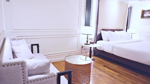 a hotel room with a bed and a couch and a chair at Buri Sriping Riverside Resort & Spa in Chiang Mai