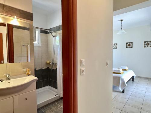 een badkamer met een wastafel, een douche en een wastafel bij Villa Seagull in Skála Kefalonias