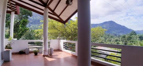 uma varanda com vista para uma montanha em Travels Nest Homestay em Gampola