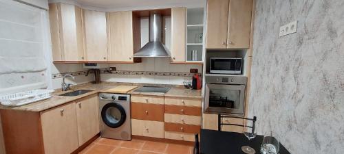 a kitchen with wooden cabinets and a washer and dryer at Apartamento Ideal in Mundaka