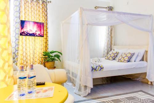 sypialnia z łóżkiem z baldachimem i stołem z butelkami wody w obiekcie SeaEsta suite 64 Nyali Mombasa w mieście Nyali