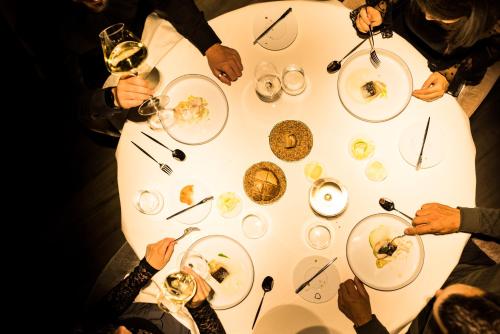 a group of people sitting at a table eating food at Hotel Weisses Kreuz in Malles Venosta