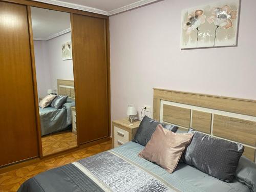 a bedroom with a bed and a mirror at Les Xanes de Candas in Gijón