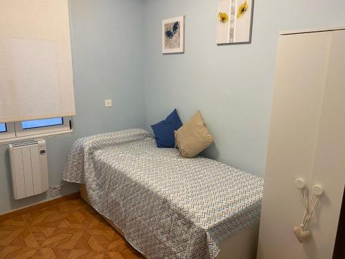 a small bedroom with a bed in a room at Les Xanes de Candas in Gijón