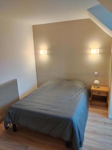 - un lit dans une chambre avec deux lumières sur le mur dans l'établissement Maison au centre de Cahors, à Cahors