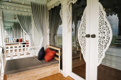 a porch with a bench on a house at Mambo Hill Resort in Nusa Penida