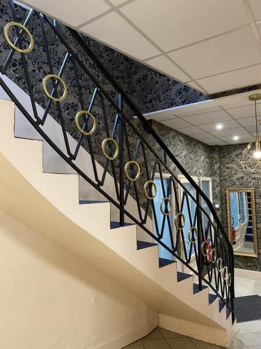 a staircase in a office with blue and white stair railing at Hôtel Aux Vendanges de Bourgogne in Paray-le-Monial