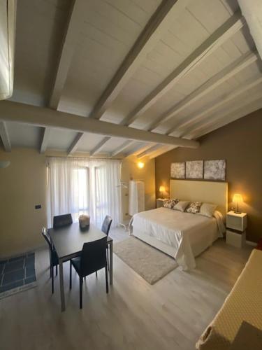 1 dormitorio con 1 cama, mesa y sillas en Il Ghetto Farm Holiday, en Soiano del Lago