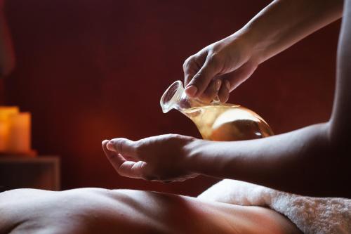 a person is washing their hands with a teapot at Spa Suite Dobrna - Terme Dobrna in Dobrna