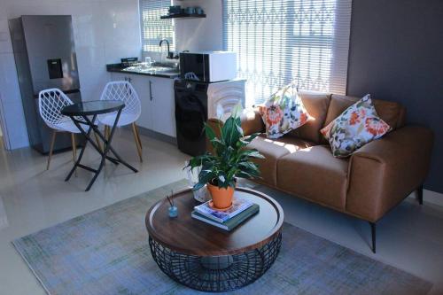 a living room with a couch and a table at Gaborone 1 bed suburban bliss in Gaborone