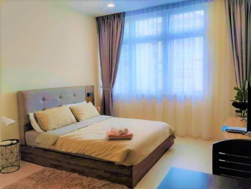 クチンにあるModern and Charming Couple Suite @Riverine Kuchingの大きな窓のあるベッドのある寝室