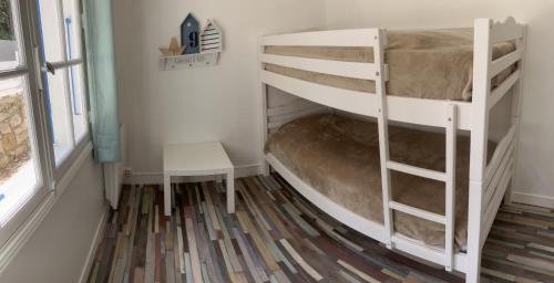 ein kleines Zimmer mit einem Etagenbett und einem Stuhl in der Unterkunft Maison 100 m2 plein pied pour 6 personnes 300 m de la plage in Chaucre