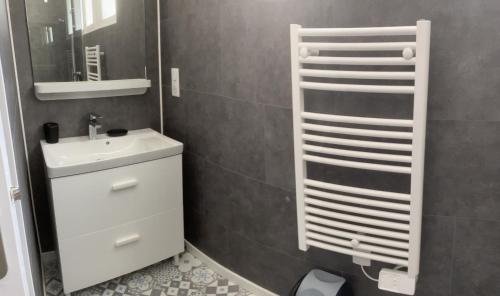 ein Badezimmer mit einem weißen Waschbecken und einem Spiegel in der Unterkunft Maison 100 m2 plein pied pour 6 personnes 300 m de la plage in Chaucre