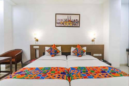 a bedroom with two beds with a colorful blanket at FabHotel Prime The Continental in Lucknow