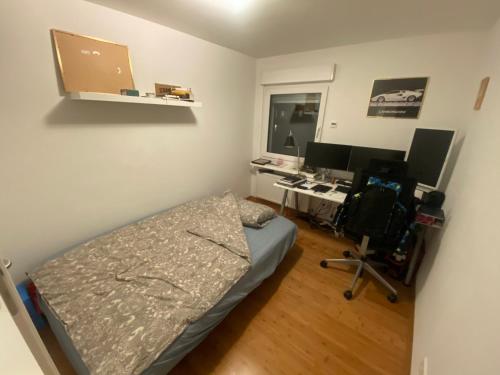ein Schlafzimmer mit einem Bett und einem Schreibtisch mit zwei Computermonitoren in der Unterkunft Central Private Room Near Messe (Fair) in Frankfurt am Main