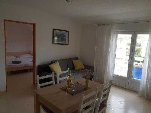 a living room with a table and a couch at Apartmani I+J Miletic in Vodice